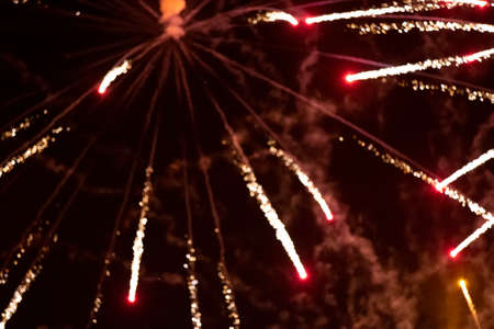 Red rays of fireworks on black background. Festive night background.