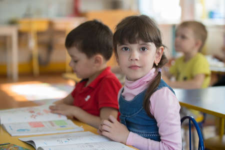 May 30, 2019 Belarus, Gomil. Kindergarten open day.Preschoolers at school desks in kindergarten.のeditorial素材