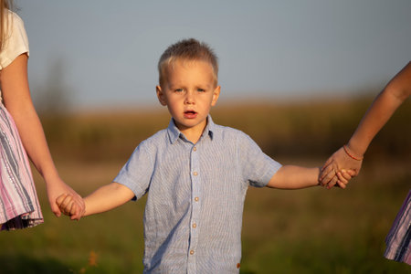 A little boy is led by the hands across the field.の写真素材