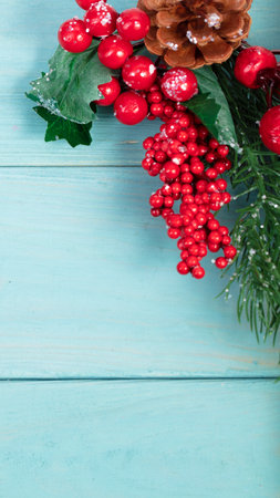 On a turquoise wood background, a decoration of a spruce branch and cones. Christmas background.の写真素材