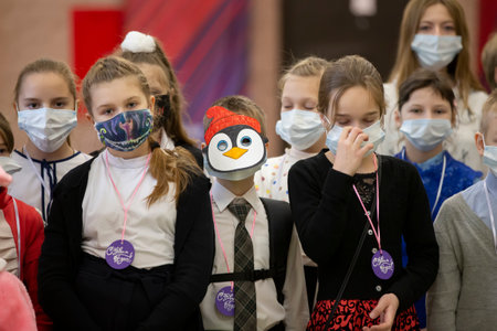 December 24, 2020. Belarus, the city of Gomil. Christmas holiday in the city during the coronavirus epidemic. Children in medical masks at the Christmas holiday during the coronavirus epidemic.のeditorial素材