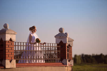 Beautiful bride with a bouquet of flowers on a walkの写真素材