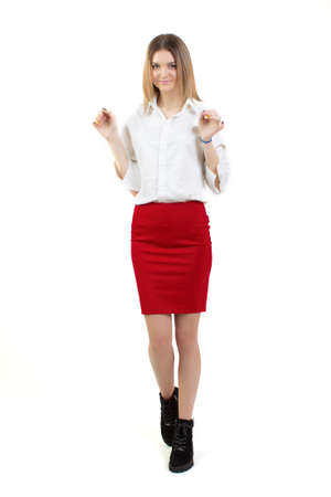 Girl in a white blouse and a red skirt in full growth on a white background.の写真素材