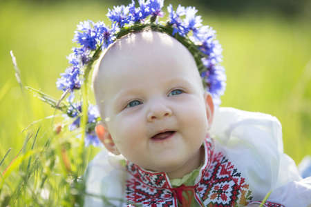 Baby girl with cornflowers in embroidered. Symbol of Belarusの写真素材