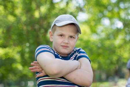 Belarus, the city of Gomel, April 04, 2018. The central kindergarten. Open day.A preschool boy in a baseball cap stands on the streetのeditorial素材