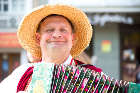 Belarus, the city of Gomel, September 15, 2018. Holiday City Day. Central Park.A man in a straw hat playing the harmonica.Harmonistのeditorial素材