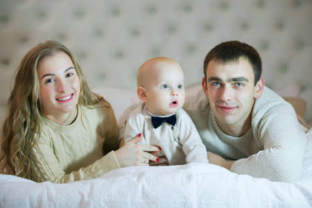 Mom dad and baby son. Parents and child. Portrait of a young familyの写真素材