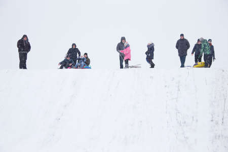 Belarus, the city of Gomel, December 31, 2018. The central quarter. People ride on a snow slide. People stand on a snow hillのeditorial素材