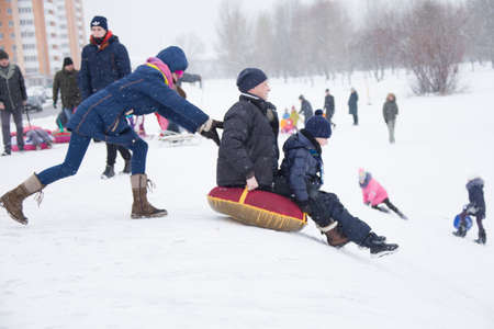 Belarus, the city of Gomel, December 31, 2018. The central quarter. People ride on a snow slide.のeditorial素材