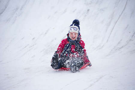 Belarus, the city of Gomel, December 31, 2018. The central quarter. People ride on a snow slide.The girl rides on sleds ice-boats from a hillのeditorial素材