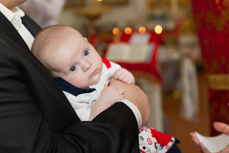 Belarus, Gomel, May 6, 2018. Church of Volotovo. Baptism of a newborn child. The baby in the hands of the godfather at the Orthodox baptismのeditorial素材