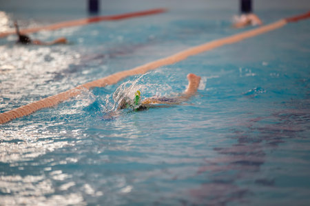 March 10, 2021. Belarus, the city of Gomil. Sports pool. Child athlete swims in the pool. Swimming section.のeditorial素材