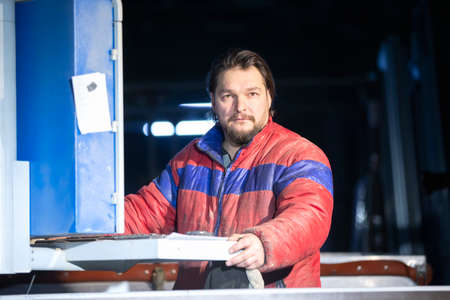 Portrait of a middle-aged working man in a dirty jacket.