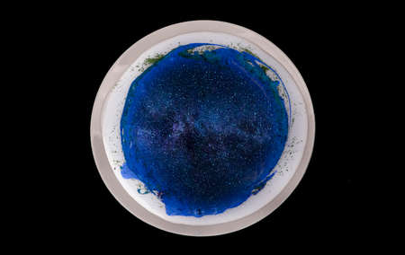 On a dark background, a plate with blue paint and sparkles. An abstract image of the galaxy or the...