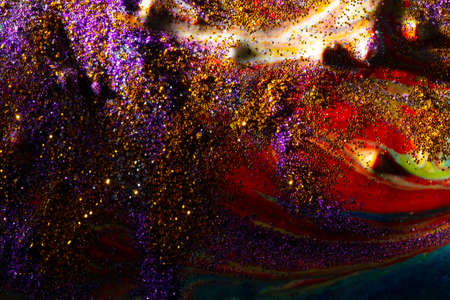 Multi-colored dark background sprinkled with purple and gold sparkles with streaks and waves....