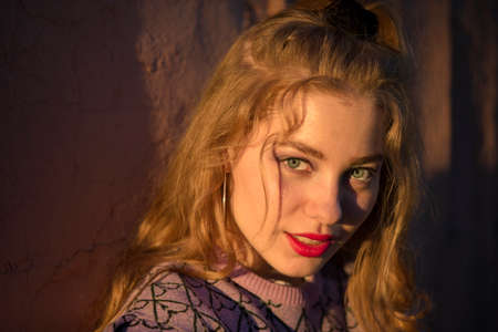 Beautiful red-haired girl in the rays of the setting sun.
