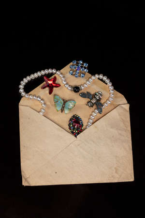 Jewelry, brooches, beads were poured out of an old mail envelope.
