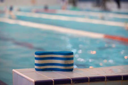 The striped swim training tool rests on the side of the pool.の写真素材