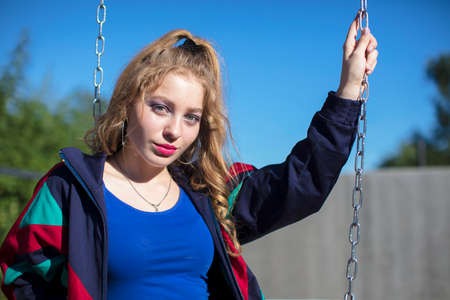 Cool teenager. A fashionable girl in a bright sports trowel in a retro style in the atmosphere of the 80s and 90s.の写真素材