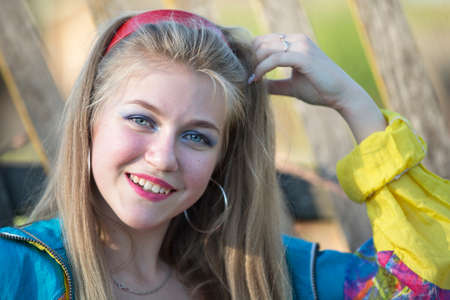 Beautiful country girl in 90s style with bright makeup and sports trowel.