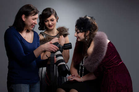 The photographer shows the photos to the models on the camera screen.の写真素材