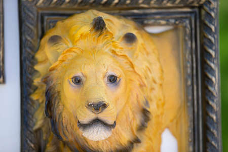 Plaster sculpture of a lion in a picture frame.の写真素材
