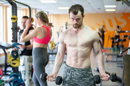 Belarus, the city of Gomil, May 06, 2021 Gym. A man of athletic build is engaged with dumbbells in the gym.のeditorial素材