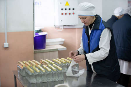 March 19, 2021 Belarus, Gomil. Factory for the production of alcoholic beverages. Worker of the bottling plant for alcoholic beverages.のeditorial素材
