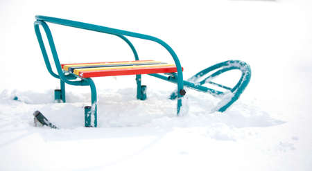 Colorful sleds on a white snowy background.