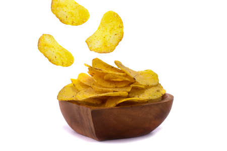 Chips are flying into a wooden plate on a white background.