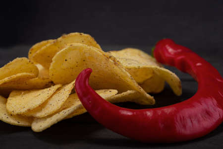 Chips with red pepper on a gray background close-up.の写真素材