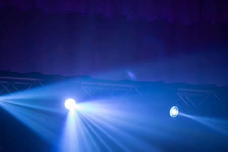 Blue rays of a stage spotlight on a dark background.の写真素材