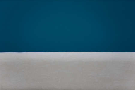 A background of white and blue fabric similar to the sand and the sea.