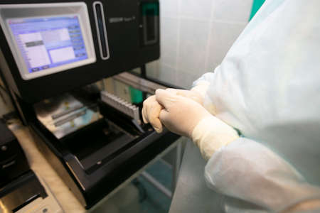 Doctor's hands in rubber gloves on the background of diagnostic equipment.