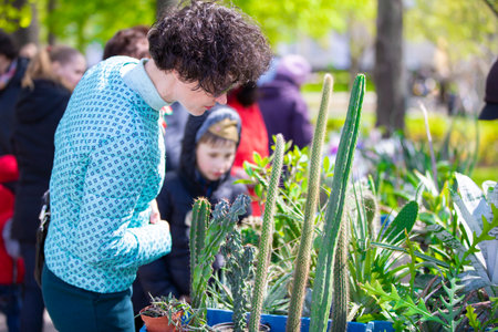 Belarus, the city of Gomel, May 09, 2021 Central market. A customer selects a cactus at the fair.のeditorial素材