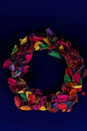 A wreath of dried multi-colored petals on a dark background.の写真素材