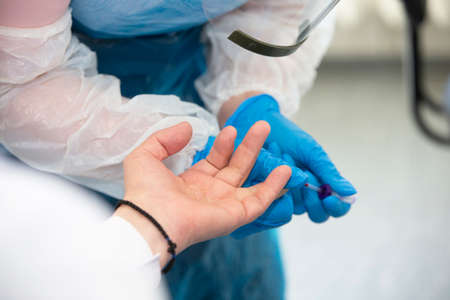 Take a blood test from a finger in a medical laboratory close-up.の写真素材