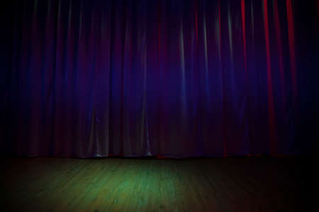 Green dark stage floor and dark purple curtains.
