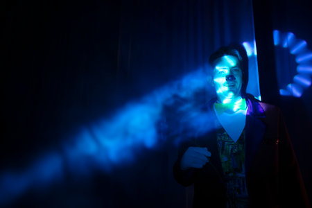 The clown's face in a beam of stage blue light.