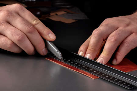 The process of making leather goods. The hands of the master work with a leather product.