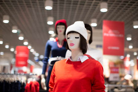 Mannequins in a clothing store in a white knitted hat and red sweater. Sale of women's clothing.の写真素材