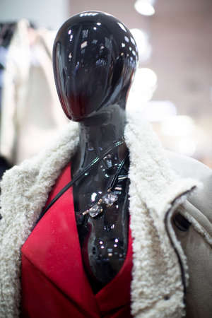 Black shiny mannequin of a woman in a shop window.の写真素材