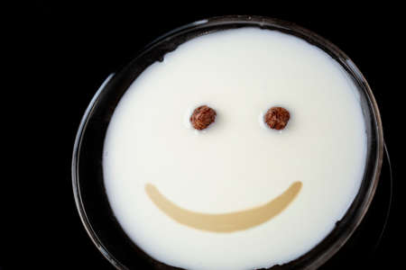 In white milk, cereal and sauce in the form of a human face.の写真素材