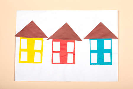 paper crafts for kids. Application of children's creativity. Kindergarten and craft school. On a beige background, multi-colored houses made of colored paper.の写真素材