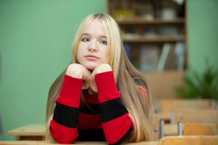 Teenager of senior school age. Teenage girl at the desk.の写真素材