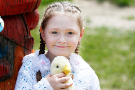 Belarus, city of Gomil, May 16, 2019. Morning in kindergarten.Little girl holding a toy duck on a summer background.のeditorial素材
