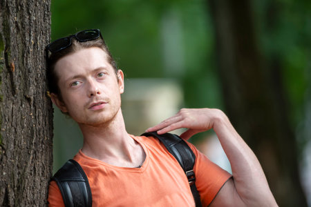 June 23, 2019 gomil city. city street. A man in casual clothes leaned against a tree.