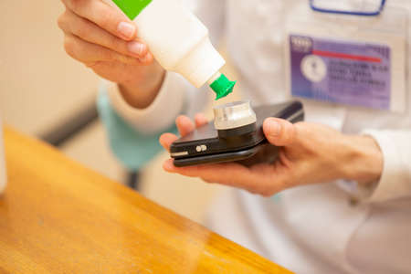 A dermatologist doctor treats with a solution of a modern device using light, a phone application...