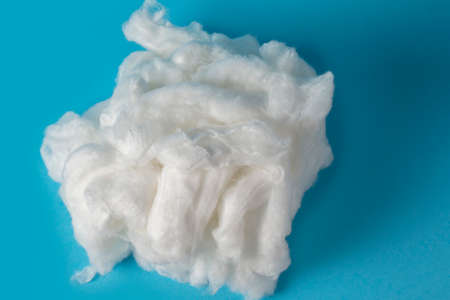 White piece of cotton wool on a blue background. Delicate cloud.Piece Cotton wool isolated on blue