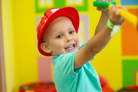 A little boy in a protective helmet plays a builder.の写真素材